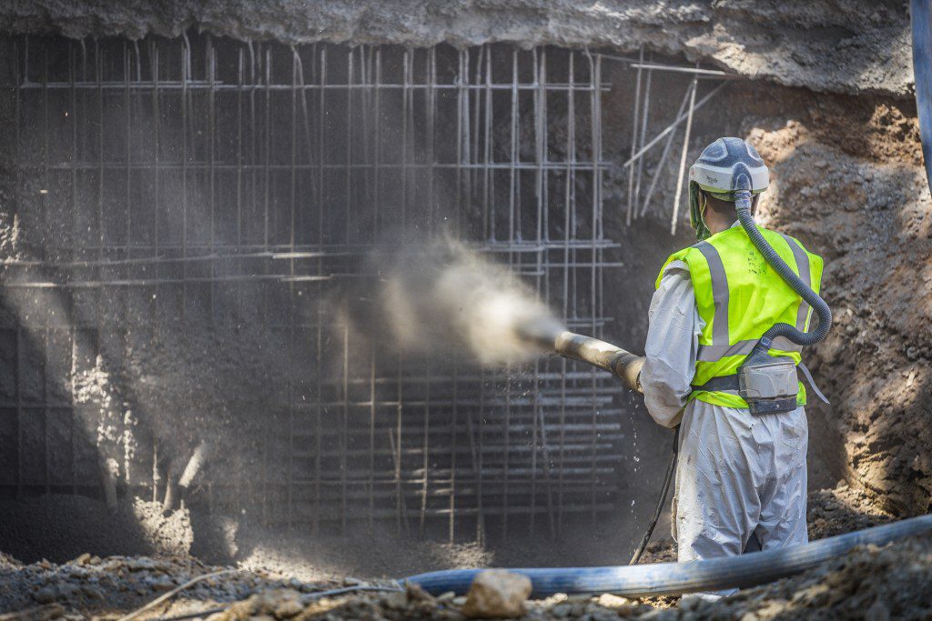 A person sprays concrete for building construction.